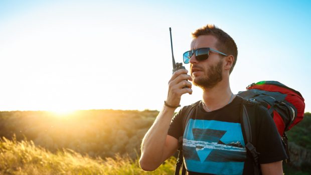 young-handsome-man-talking-walkie-talkie-radio-enjoying-canyon-view